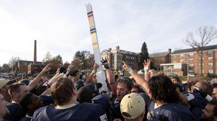 The Eagles hoist the Goalpost Trophy after defeating Susquehanna 17-10 in 2013